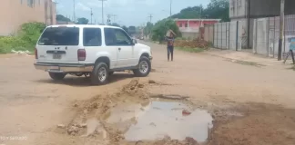 Un hombre utiliza barro para tapar los huecos de la calles en Valle de la Pascua